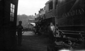 Two men standing beside freight car