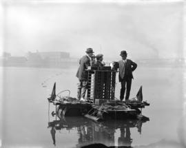 [Three men, including Distribution Engineer Mr. Busch (in bowler hat), on float in False Creek co...