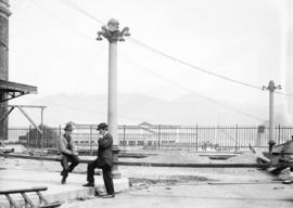 [Two men at partially constructed driveway at east end of C.P.R. station]