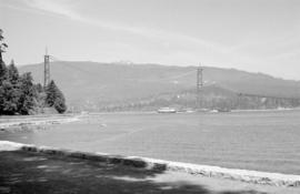 [View from the seawall of a ship passing under the Lions Gate Bridge under construction]