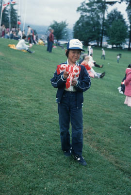 Boy holding Canadian flags during the Centennial Commission's Canada Day celebrations