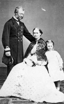 [Group portrait of] Commodore and Mrs. Powell and Daughter