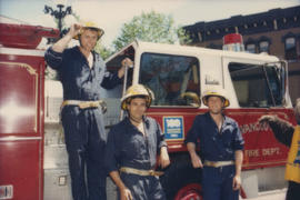 Firefighters standing next to fire engine