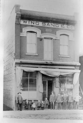 Yip Sang with children and family members in front of Wing Sang Company building at 51 East Pende...