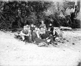 [Men and women assembled on beach for picnic]