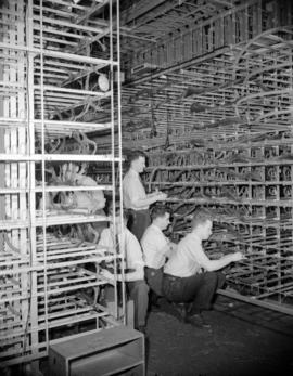 [B.C. Telephone technicians working on equipment]