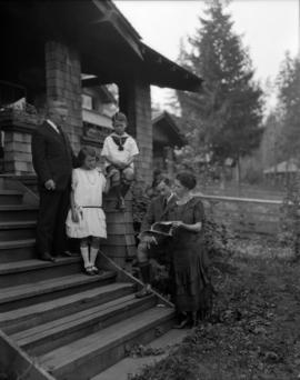 Mr. Pooley and family [on steps of house in Dollarton]