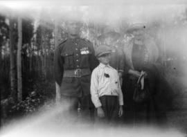 Three people with a man in military uniform