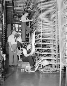 [B.C. Telephone technicians working on equipment]