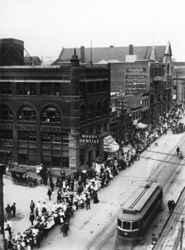 [View of the 300 block West Hastings Street at Hamilton Street with a queue of  people on the sid...