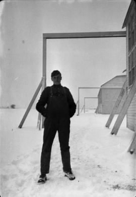James Crookall outside hangar [in] snow [at Camp] Everman