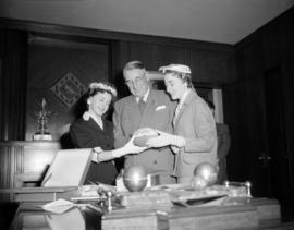 [Mayor Hume in his office with two women looking at a football as part of the events surrounding ...