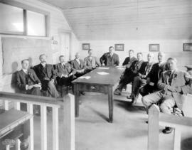 [A group of unidentified men seated around a table]