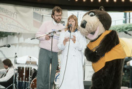 Man, woman and Tillicum on stage at Robson Square