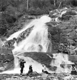 [People sitting at the base of  Granite Falls at the north end of Indian Arm]