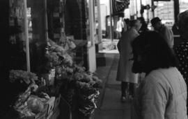 Sidewalk flower display and pedestrians