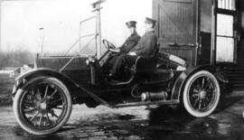 [Two firemen in Point Grey Fire Department Chief's automobile]