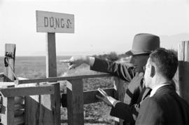 [Two men in front of "Dung St." sign]