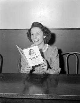 [Woman reading promotional material on telephone operators]