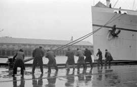 [Longshoremen tying up the "Empress of Canada" to dock]