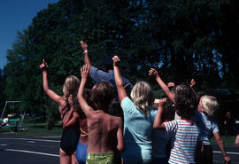 [Man and group of children with left arms raised]