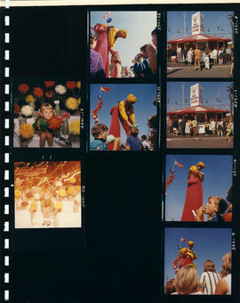 Concession stand, performer on stilts, and girl with flowers on P.N.E. grounds