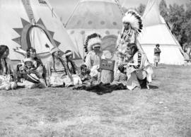 [Stoney Indian group listening to a radio on Calgary Stampede grounds]