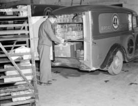 [Man loading bread into a 4X Canadian Bakeries delivery truck]