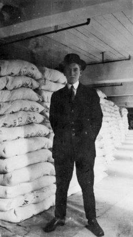 Man in suit beside bags of sugar