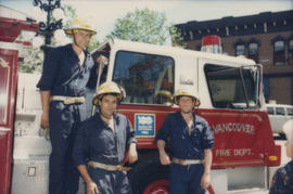 Firefighters standing next to fire engine