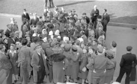 [Group of Doukhobors surrounded by a crowd in front of the courthouse]