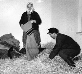 [Hungarian refugees prepare a bed in straw in the Immigration Building at the airport]