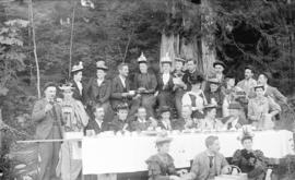 [Men and women eating strawberries at a picnic in Stanley Park]