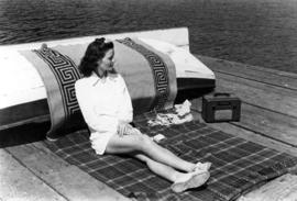 [Woman on resort wharf sunbathing]