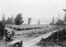 [View of crowd lining a field to watch a sporting activity]