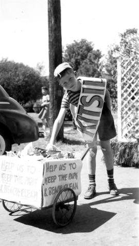 Young boy with garbage cart at a Kitsilano parade