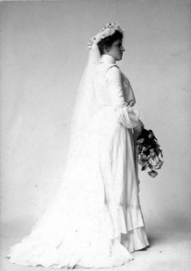 Side view of woman in wedding dress holding flowers