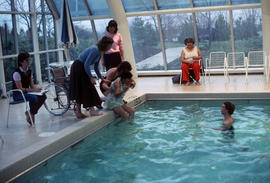 Volunteers assisting woman at swimming pool