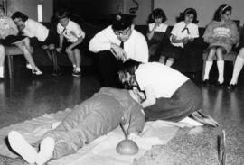 [Vancouver Fire Department staff observing mouth-to-mouth resuscitation with group of girl guides]