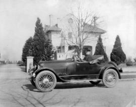 [Deputy Chief C.W. Thompson at wheel of automobile in front of house, location unknown]