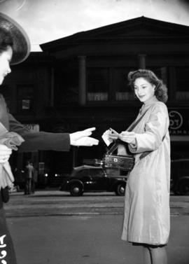 [Portrait of Audrey Gibson, street photographer handing a receipt to a customer]