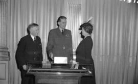 [Group standing around glass case containing Nelson's telescope after its presentation to the City]