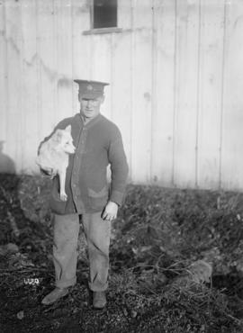 [Soldier holding a dog]