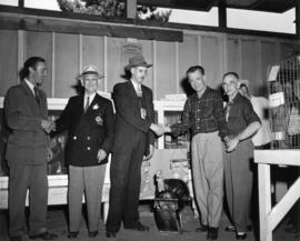 P.N.E. director T. Sommerville with unidentified men and grand champion turkey in 1953 P.N.E. pou...