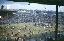 [Fans crowded on football field at 1958 Grey Cup game]