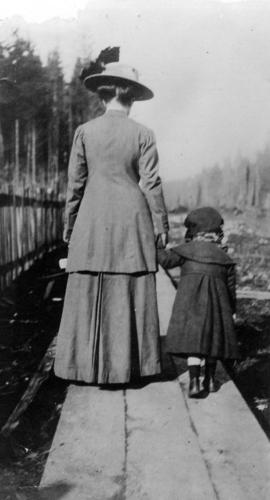 [Mrs. Buswell and her daughter walking away from the camera near Boundary Road]
