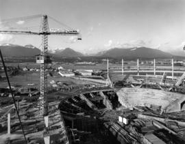 Construction of Pacific Coliseum, with view of North Shore mountains and Second Narrows Bridge