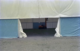 Man operating forklift inside event tent