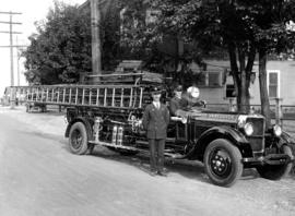 [Two members of South Vancouver Fire Department with Studebaker C.S.T. by roadside]