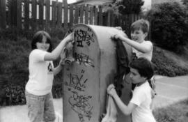 Jasmine Gibbons, Troy Zwolinski and David LeBrun clean graffiti off mailbox